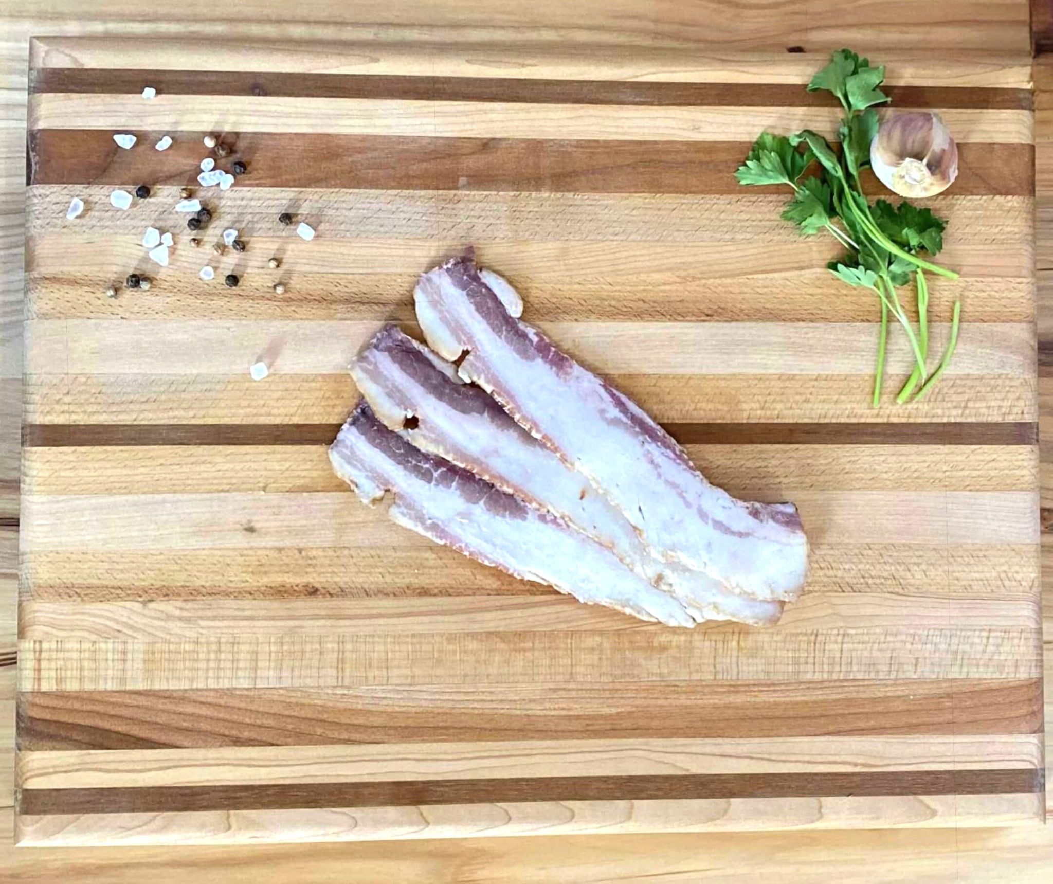 A wooden cutting board with some meat on it