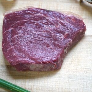 A piece of meat on top of a cutting board.