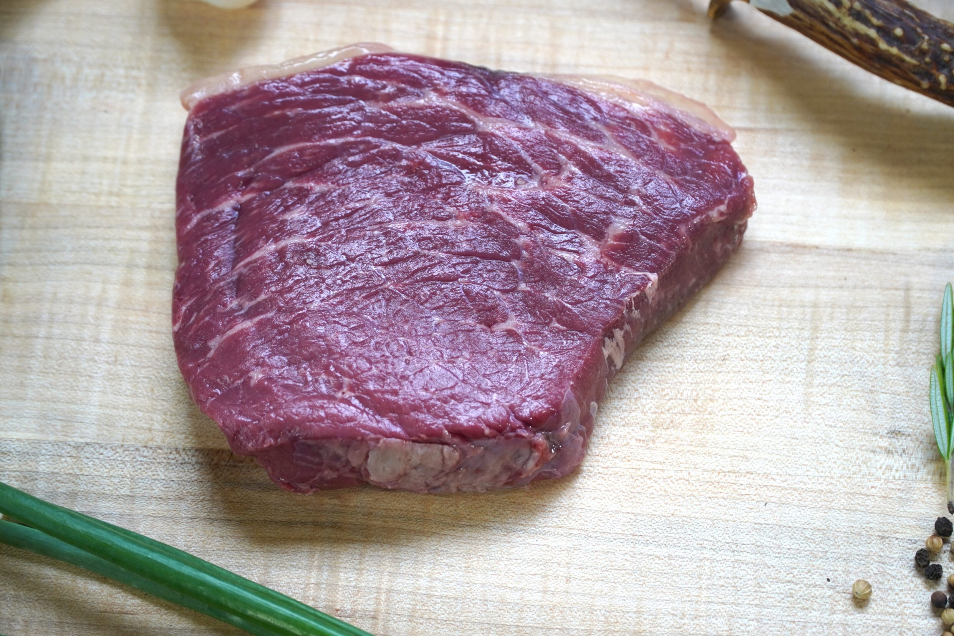 A piece of meat on top of a cutting board.