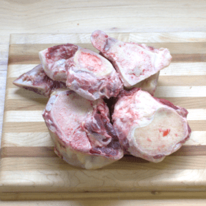 A wooden cutting board with meat on it.