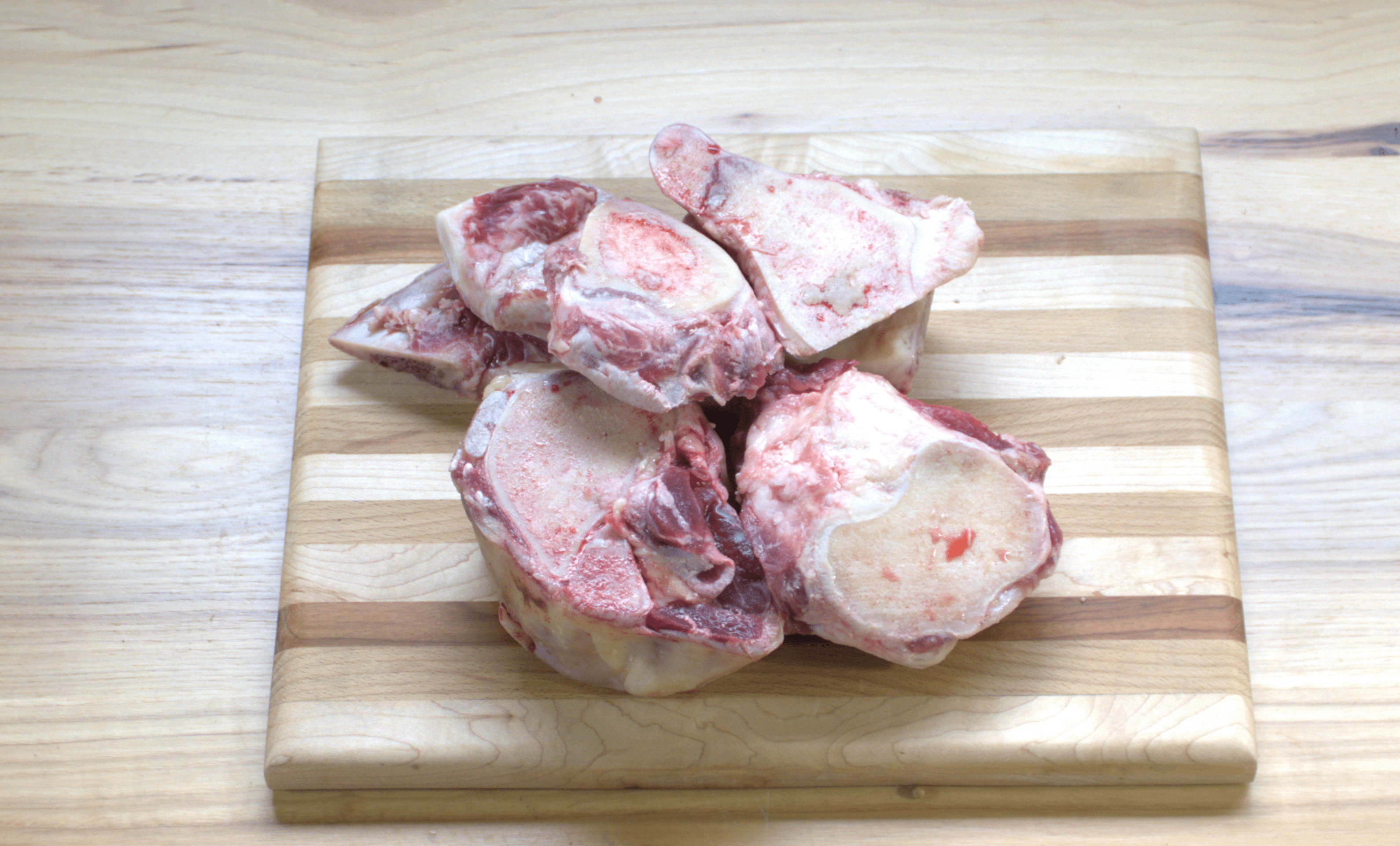 A wooden cutting board with meat on it.