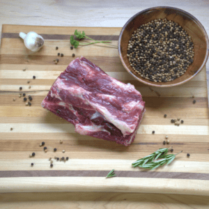 A piece of meat on top of a cutting board.