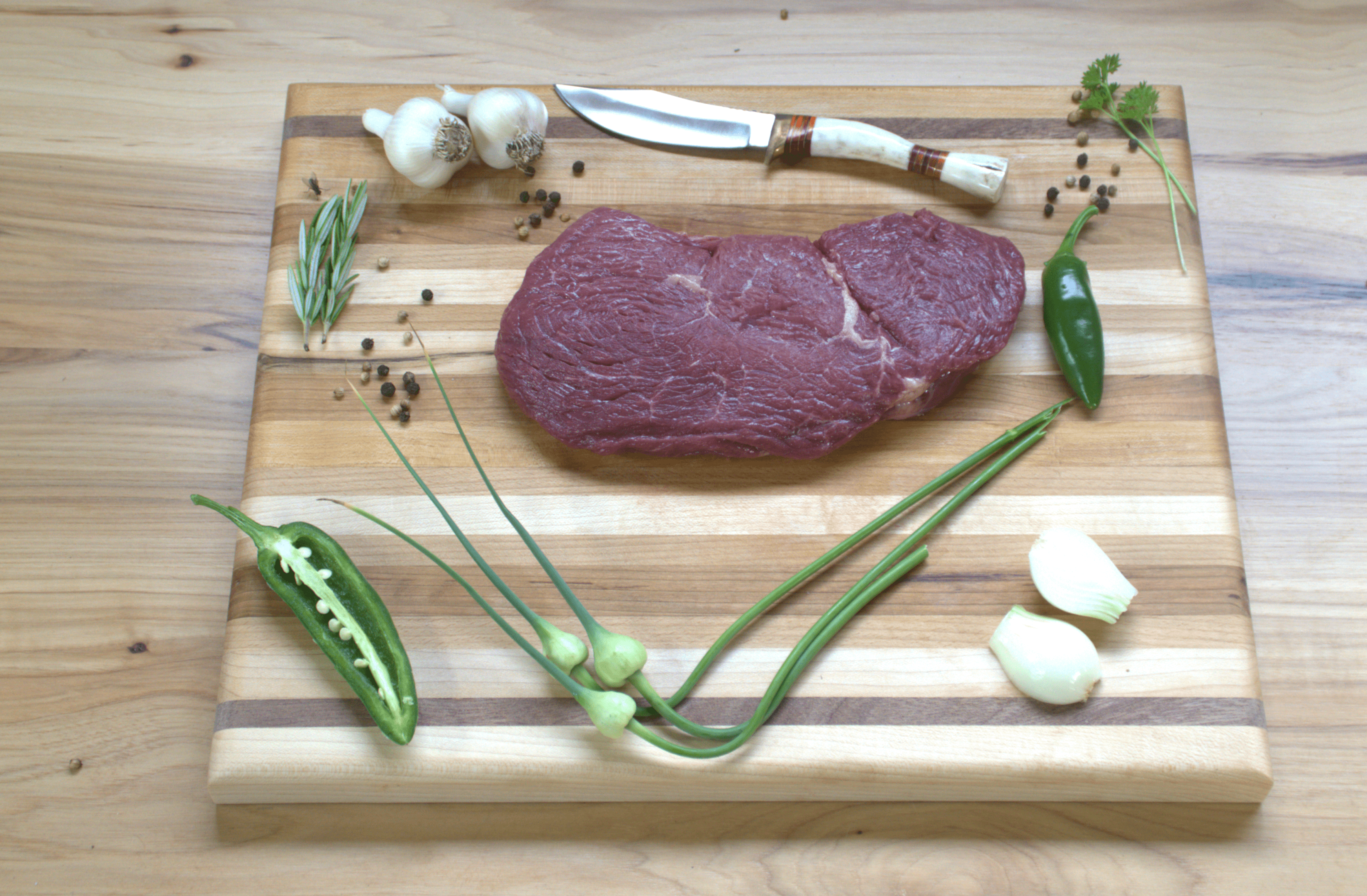 A piece of meat on top of a cutting board.