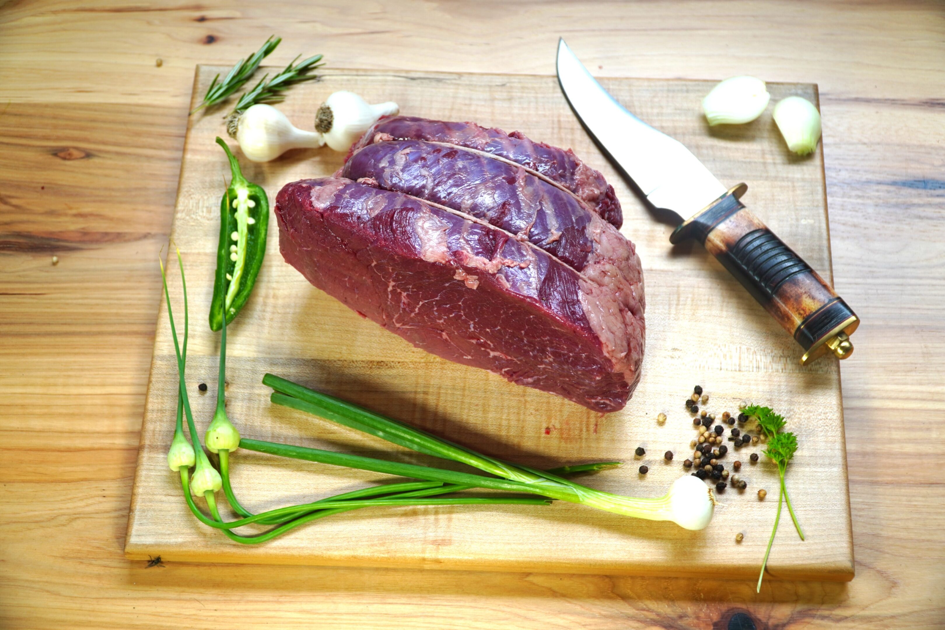 A piece of meat on top of a cutting board.