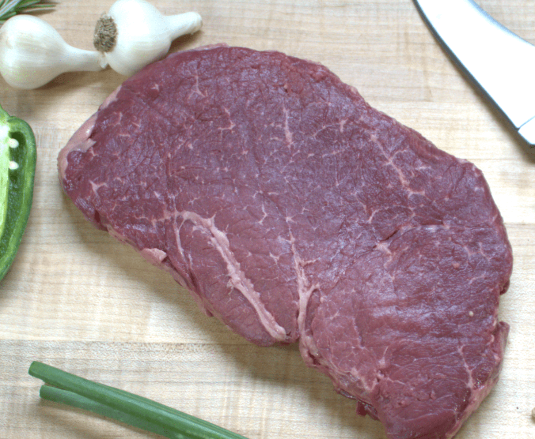 A piece of meat on top of a cutting board.