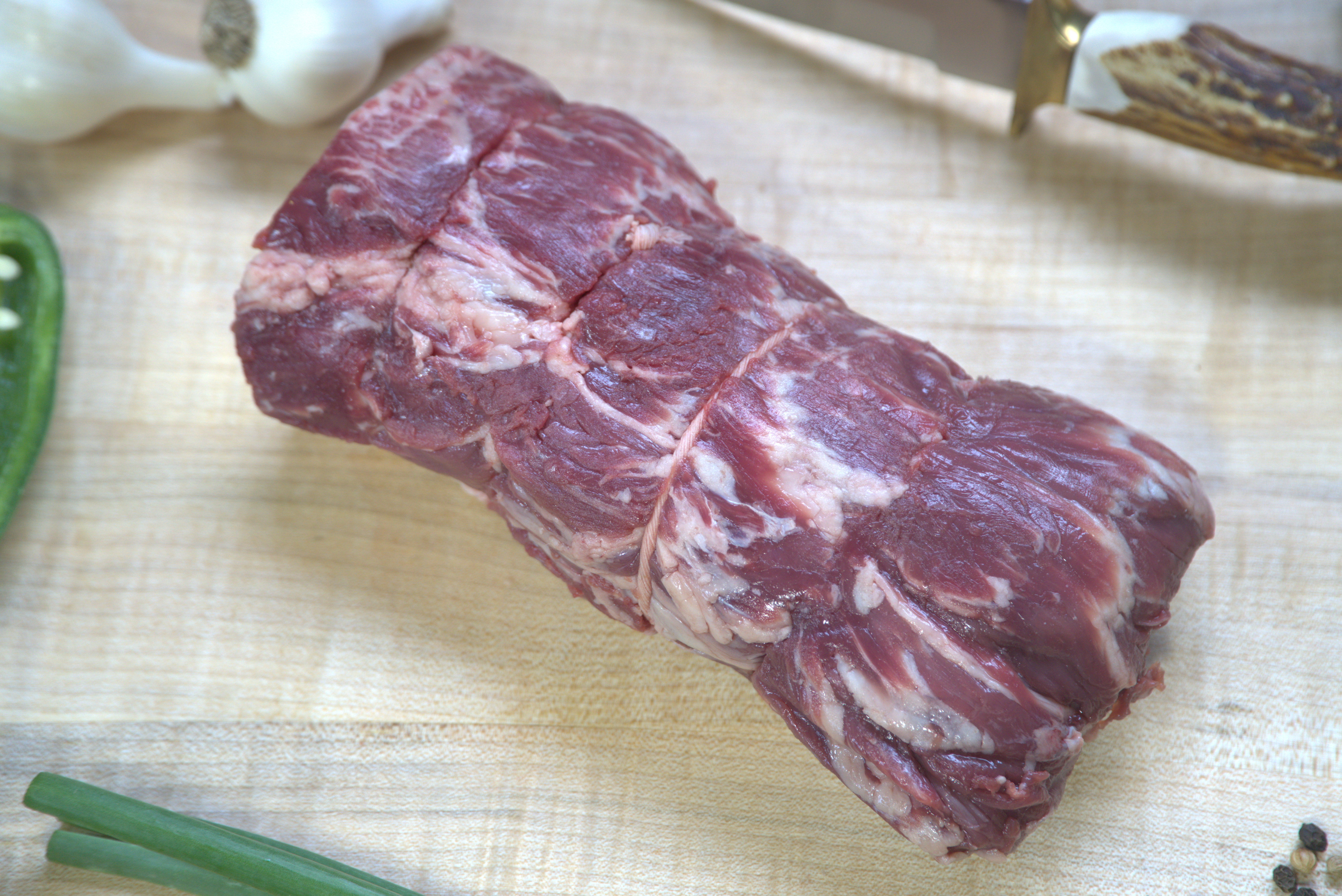 A piece of meat on top of a cutting board.