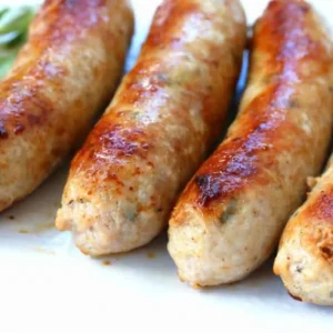 A close up of four sausages on a plate