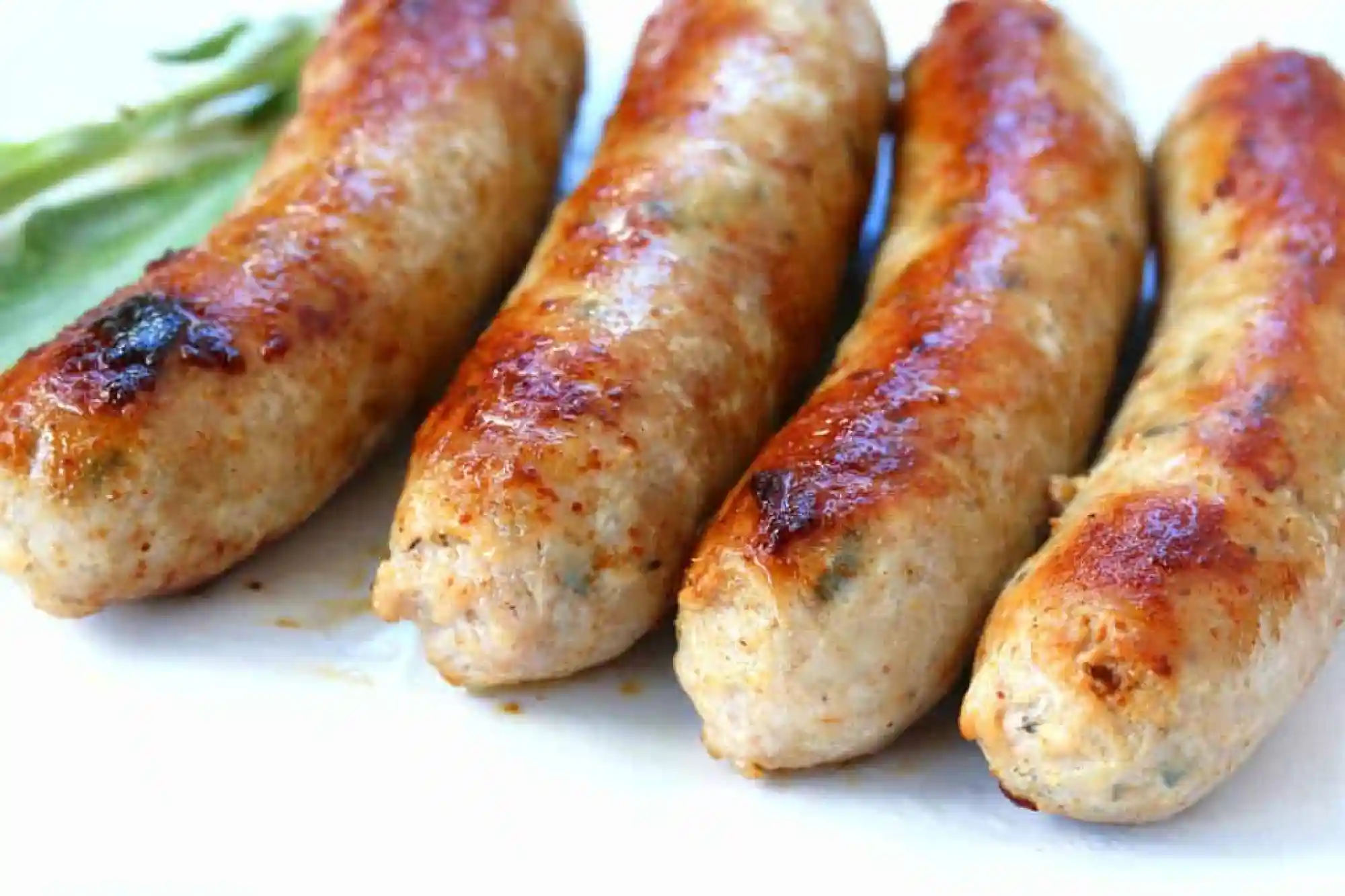 A close up of four sausages on a plate