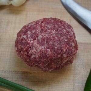 A hamburger sitting on top of a wooden cutting board.