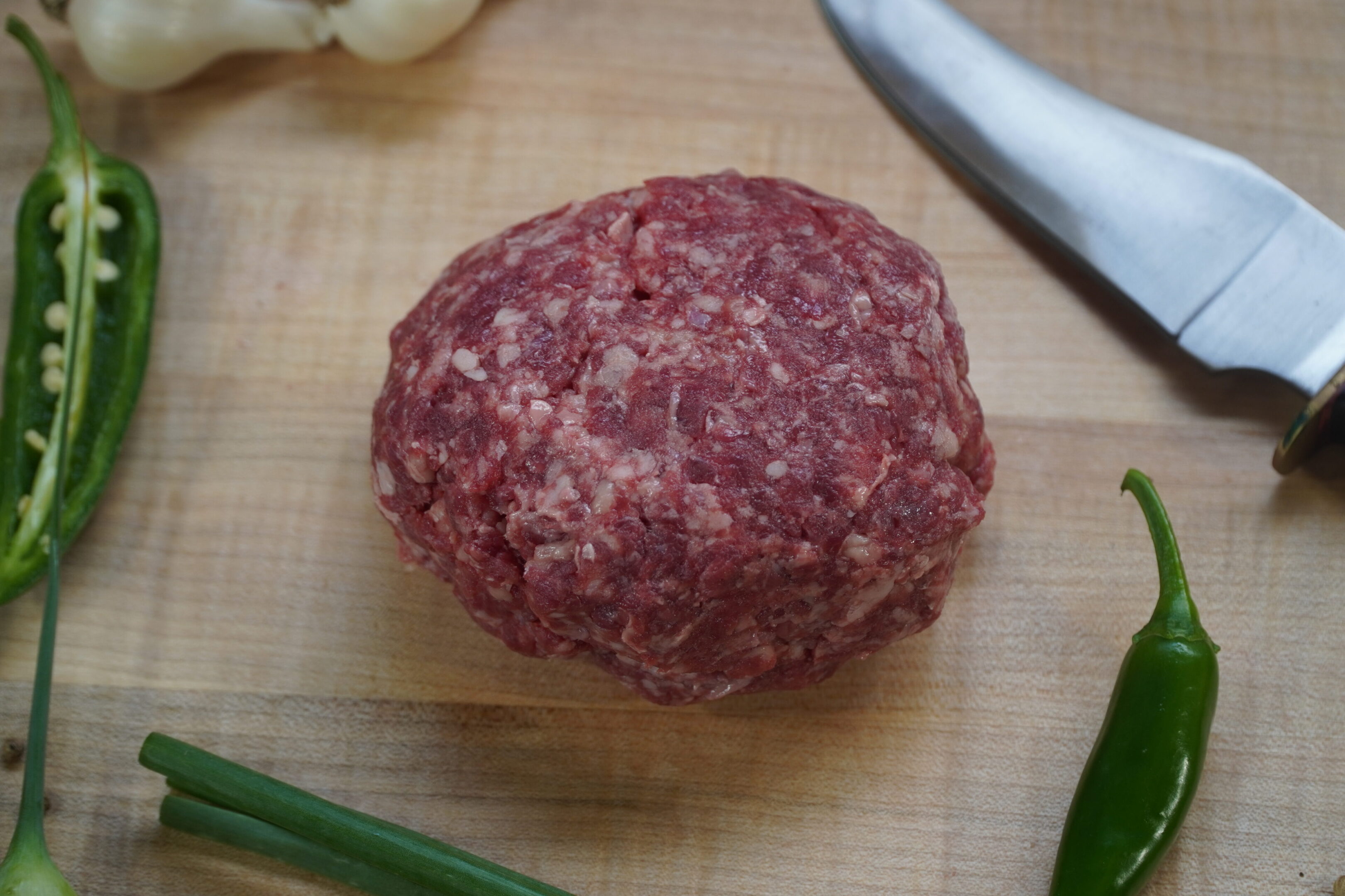 A hamburger sitting on top of a wooden cutting board.