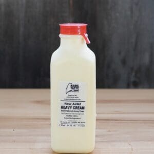 A bottle of cream on top of a wooden table.