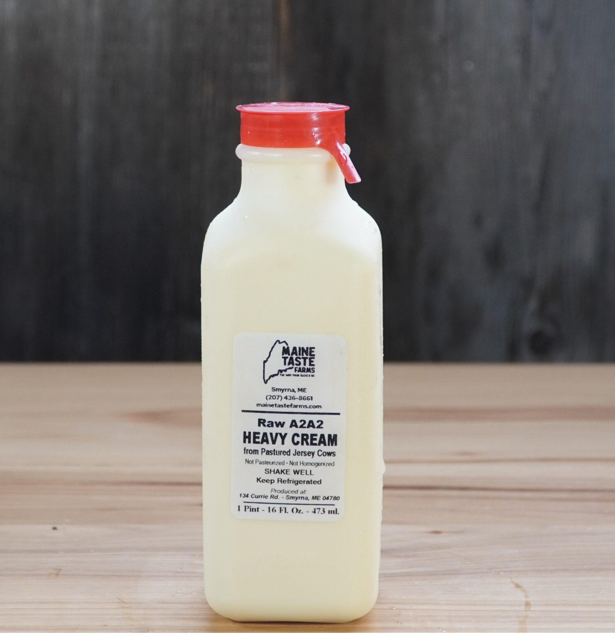 A bottle of cream on top of a wooden table.