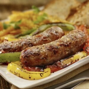A plate of food with sausage and peppers on it.