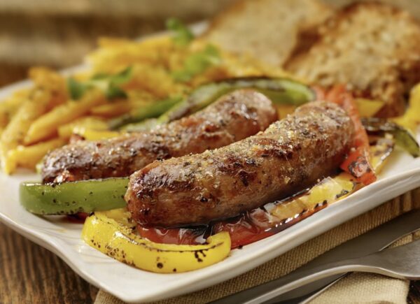 A plate of food with sausage and peppers on it.