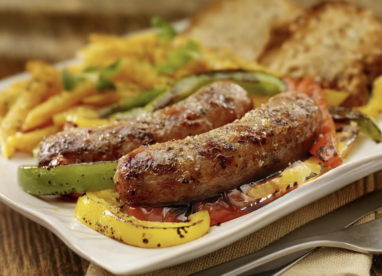 A plate of food with sausage and peppers on it.