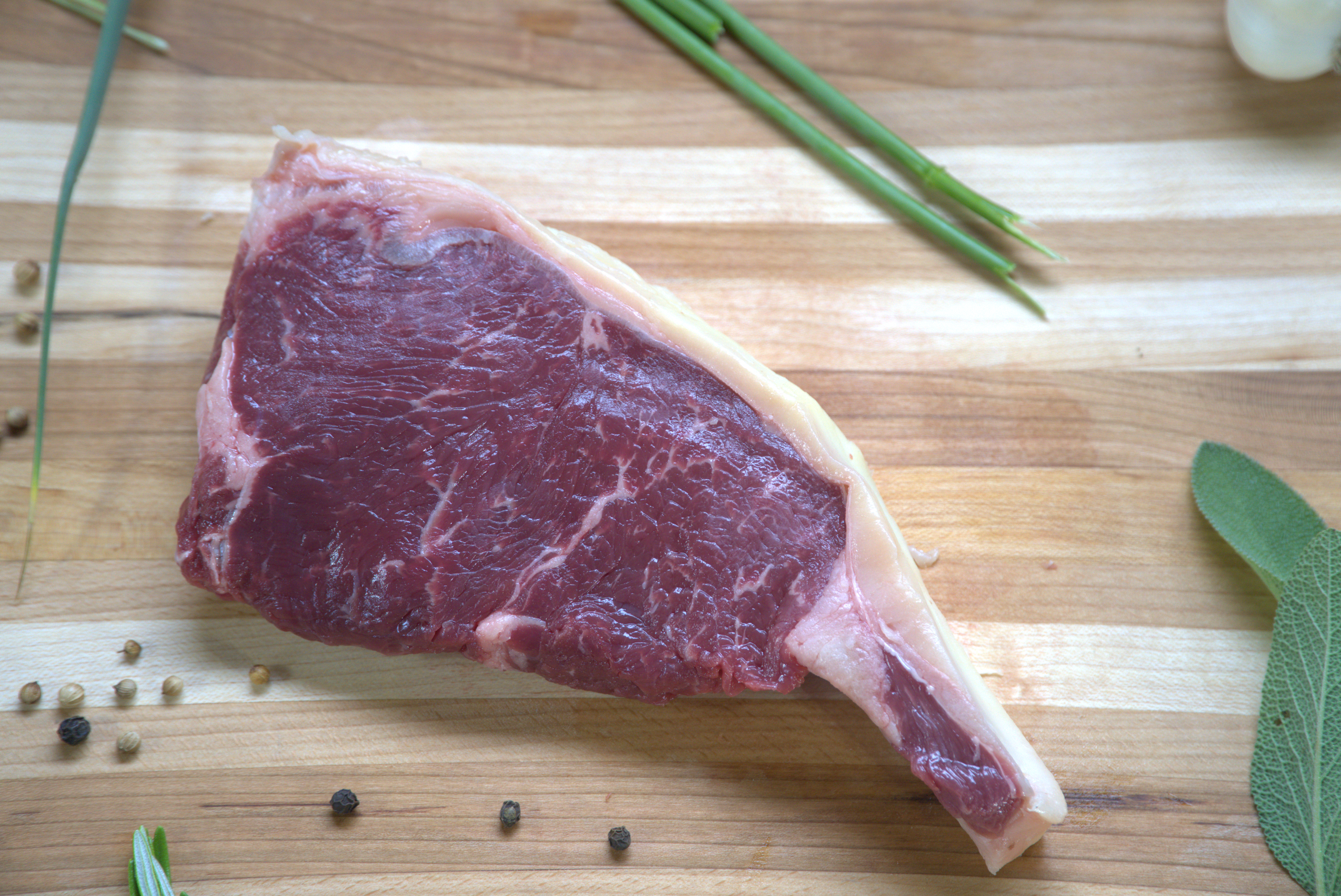 A piece of meat on top of a wooden cutting board.