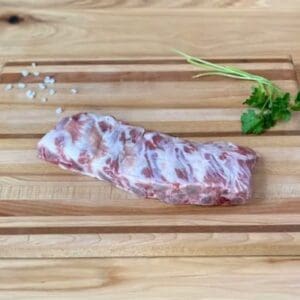 A piece of meat on top of a wooden cutting board.