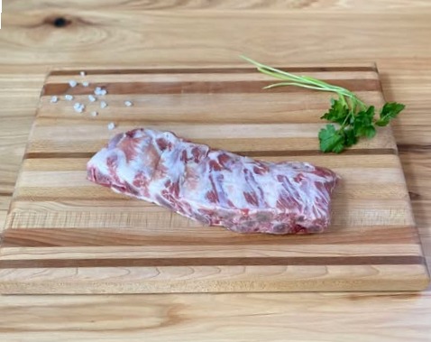 A piece of meat on top of a wooden cutting board.