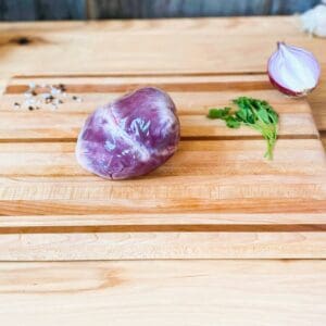 A cutting board with some meat and vegetables on it