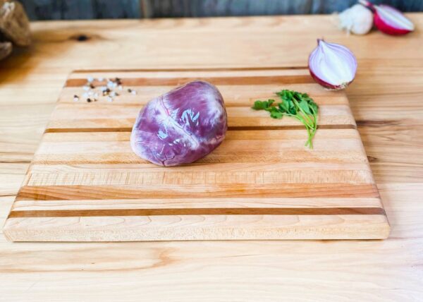 A cutting board with some meat and vegetables on it