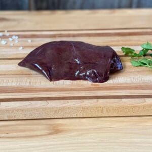 A piece of chocolate sitting on top of a wooden board.