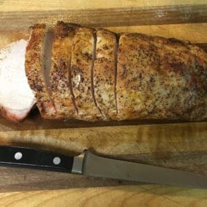 A knife and some meat on a cutting board