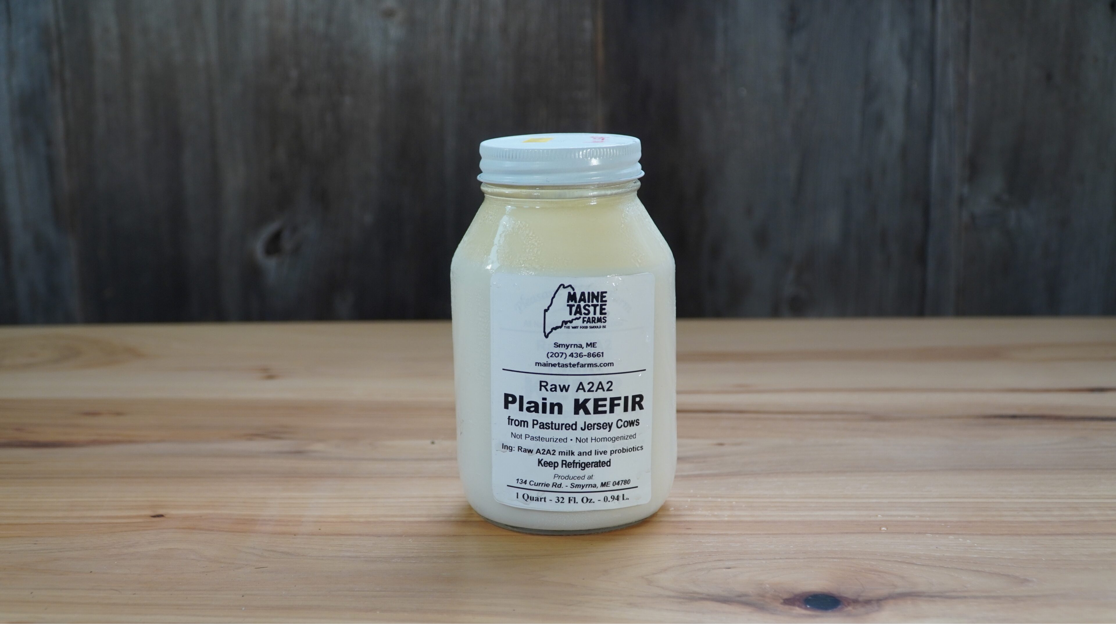 A jar of plain kefir on top of a wooden table.