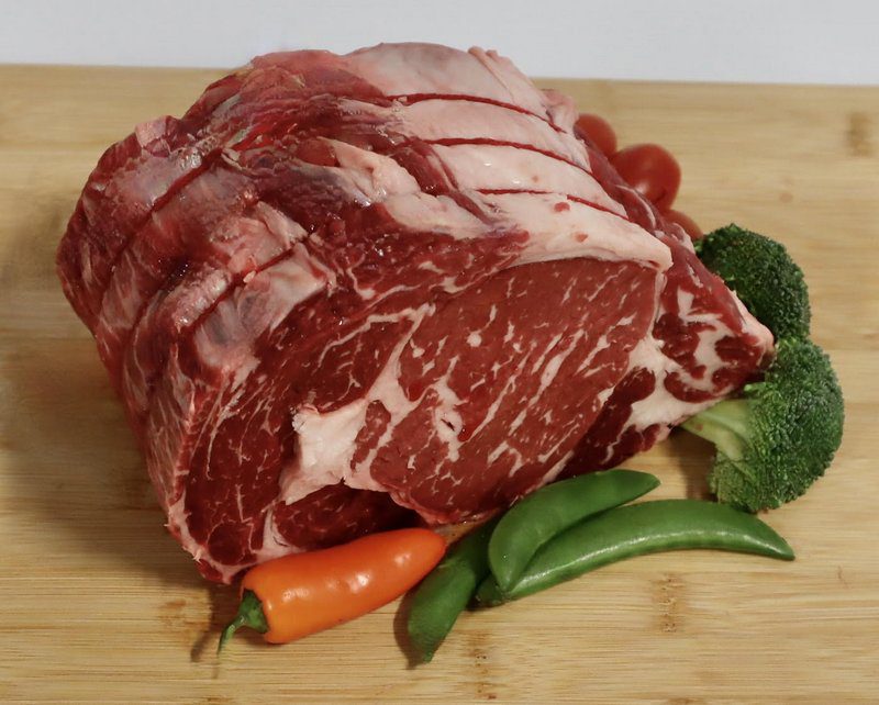 A raw meat and vegetables on a cutting board.